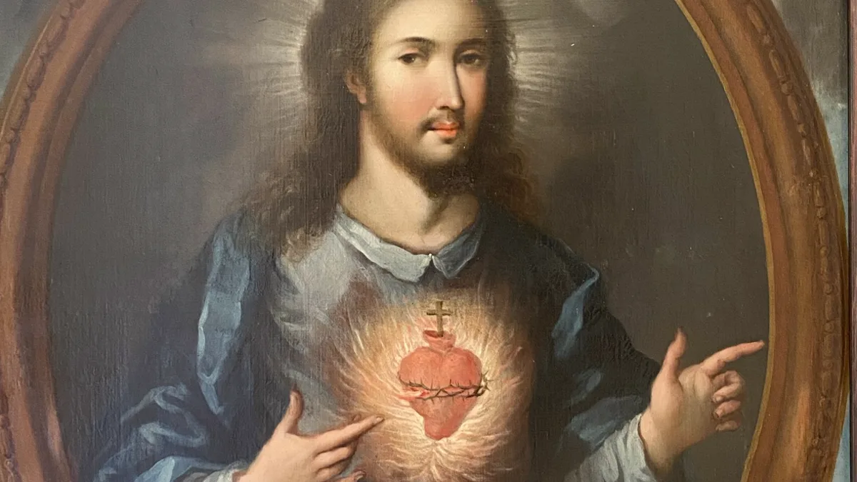 Óleo del Sagrado Corazón de Jesús: Cristo con túnica azul dentro de un marco ovalado, señalando con las dos manos el corazón llameante coronado de espinas y rematado por una cruz